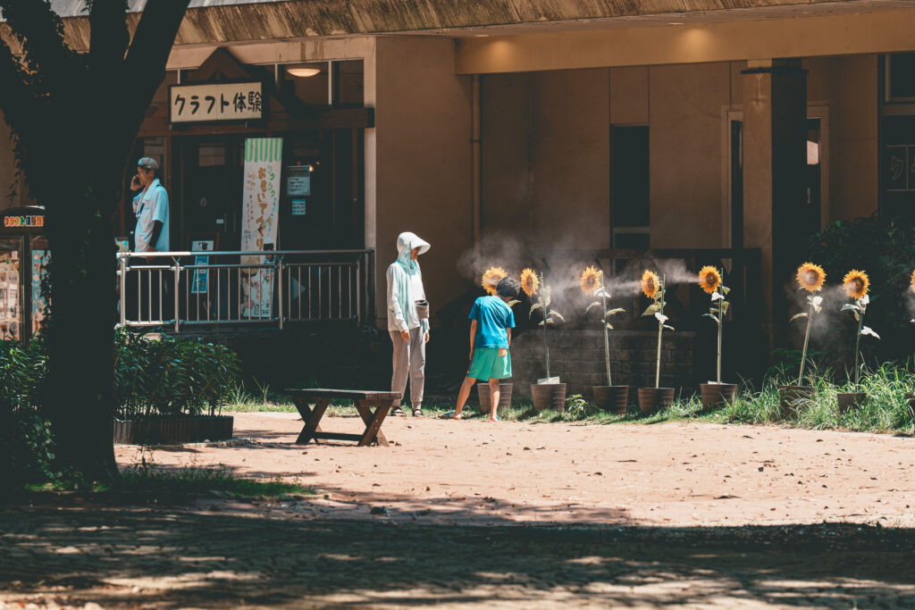 ひまわりの霧吹きで涼む親子