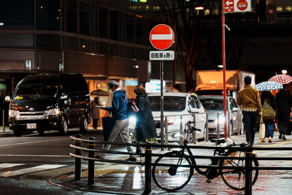 スマホをいじりながら横断歩道を渡る人