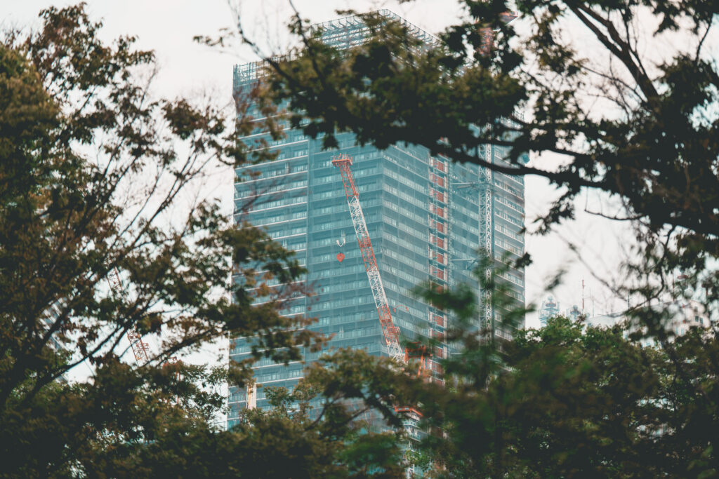 木々の間から覗く建設中のビル