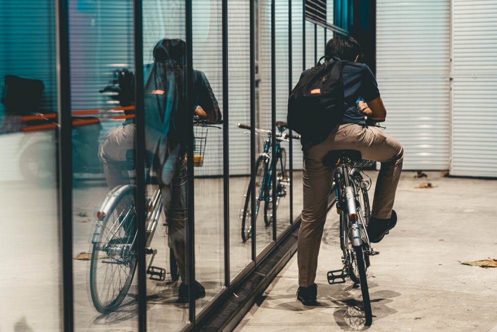 ガラスに反射する自転車に乗った男性