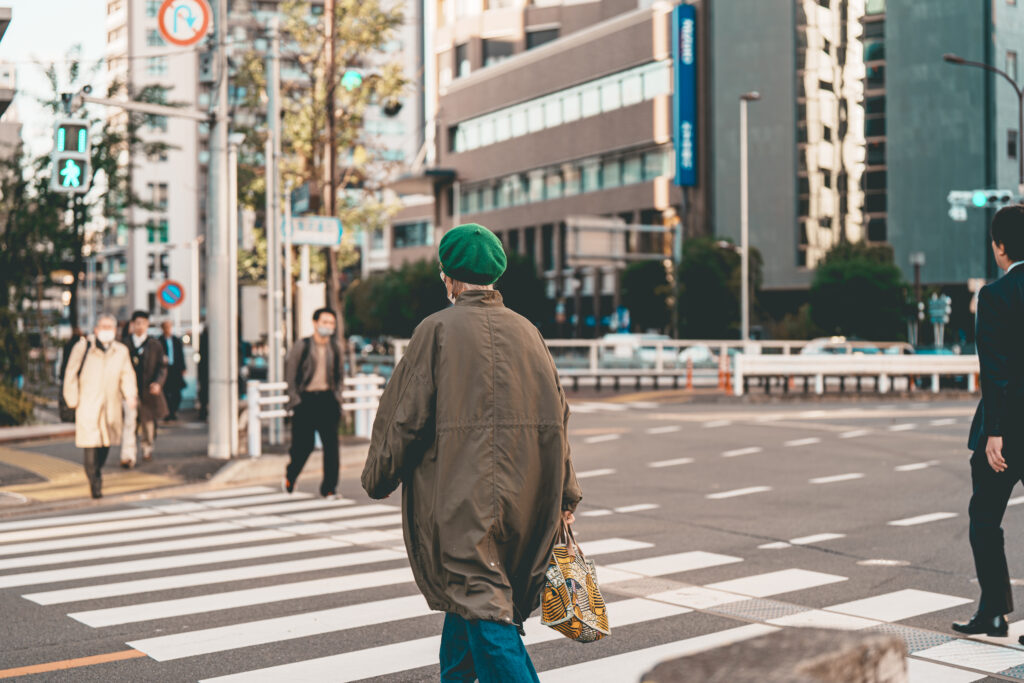 横断歩道を渡る緑の帽子をかぶった女性